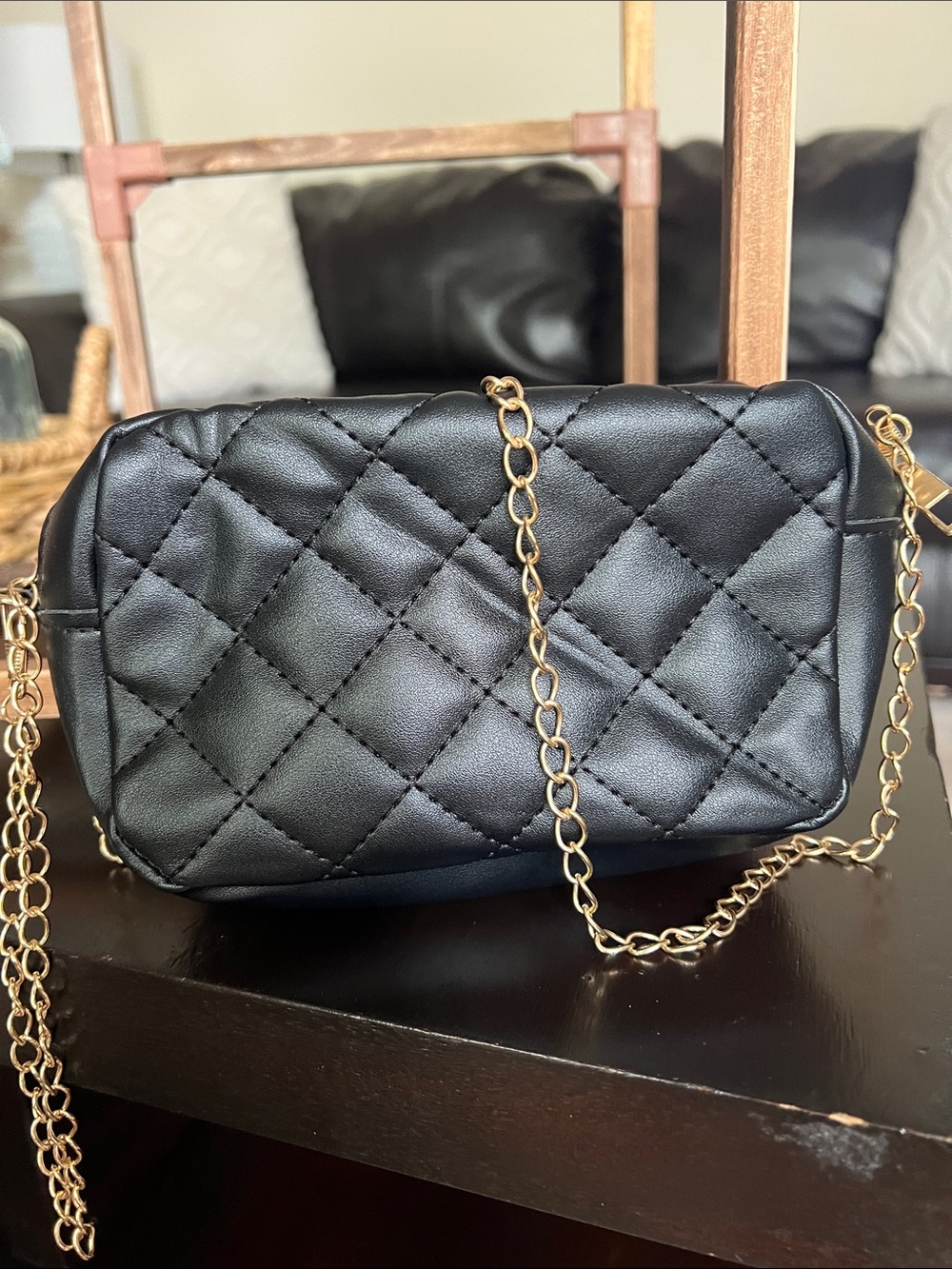 Textured black crossbody purse with gold chain.